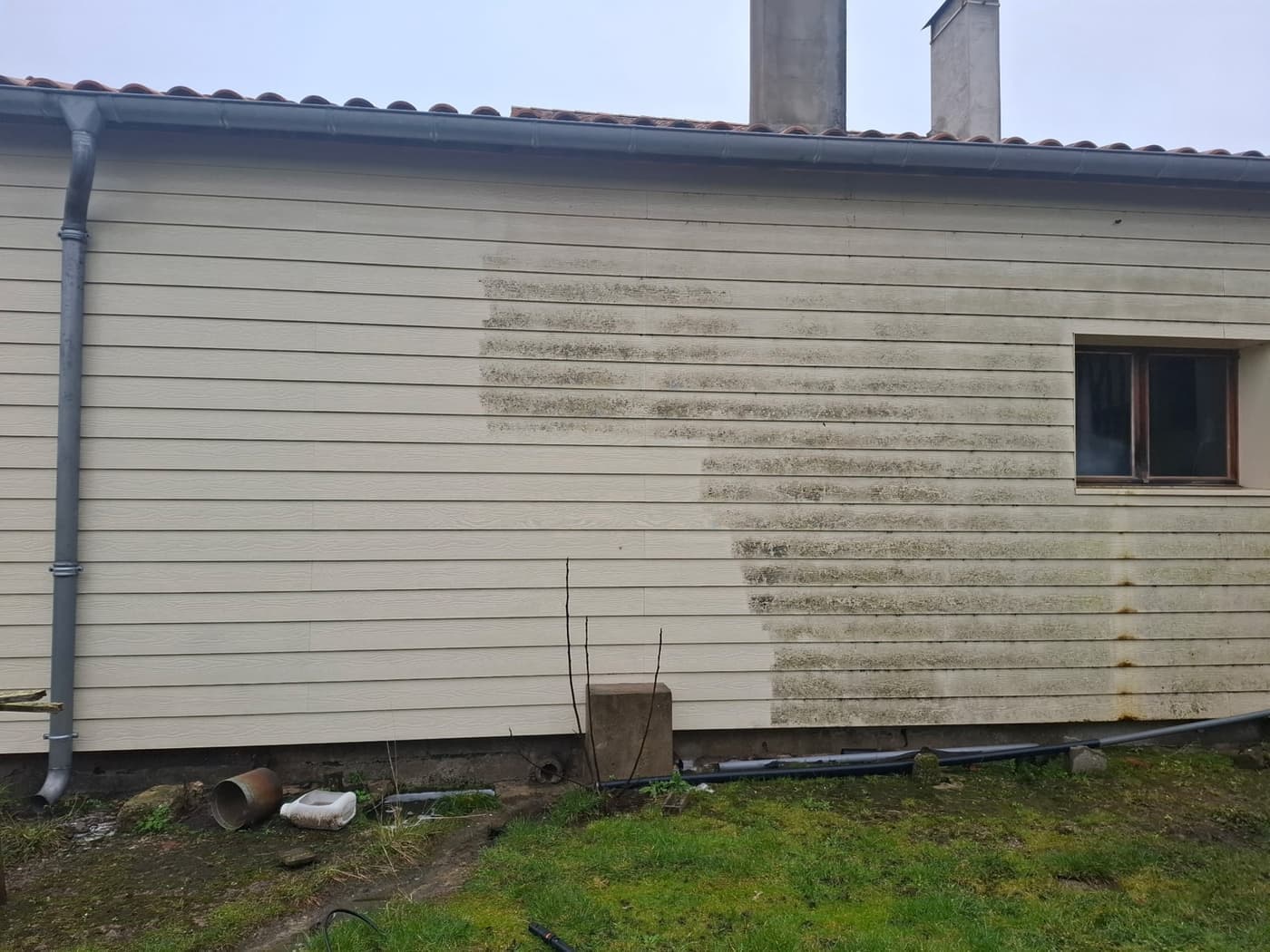 Bardage bois en cours de nettoyage, partie gauche traitée et partie droite encore chargée de traces vertes