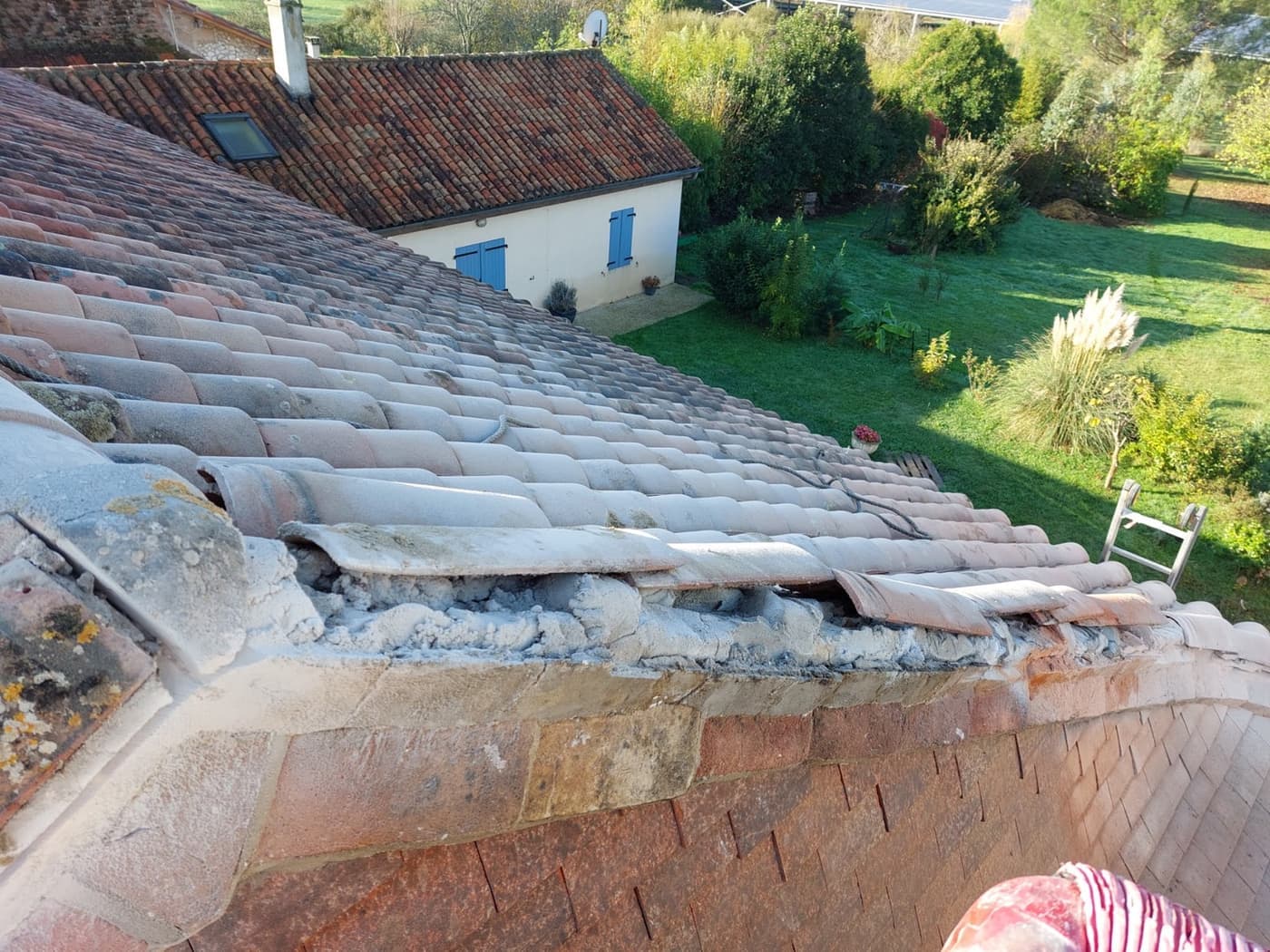 Faîtage en cours de rescellement au mortier sur une toiture en tuile canal